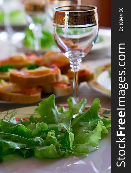 A plate with fresh green salad and a glass. A plate with fresh green salad and a glass