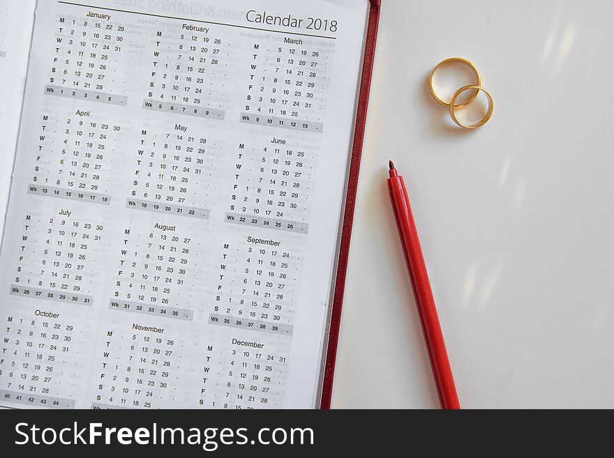 Planning a wedding in 2018. Calendar of 2018 and two wedding rings and on white background