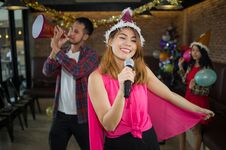 Asian Woman Singer In Santa Claus Hat With A Microphone Singing Stock Photo