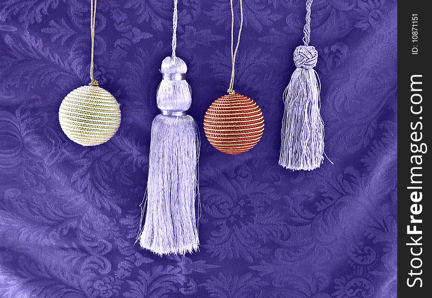 Silver Tassels and Christmas balls on a purple background. Silver Tassels and Christmas balls on a purple background