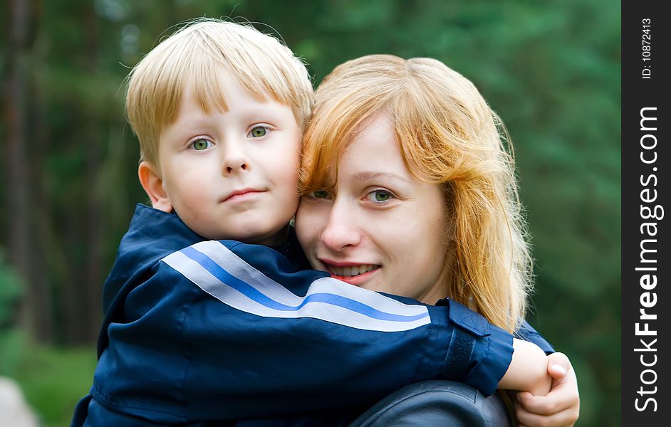 Smiling mother holding her little son in her arms. Smiling mother holding her little son in her arms