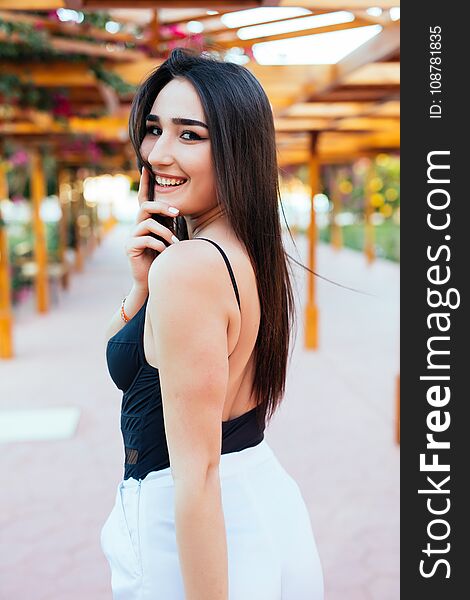 Fashion stylish trendy sensual portrait of pretty young woman posing outdoor in summer in the beach cafe having fun alone