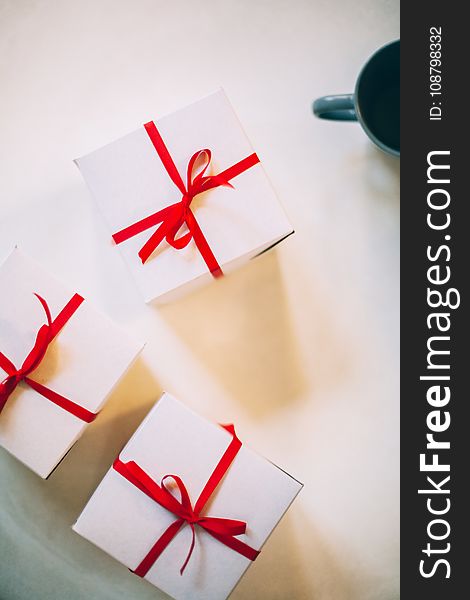 Photography of Three Boxes With Red Ribbons