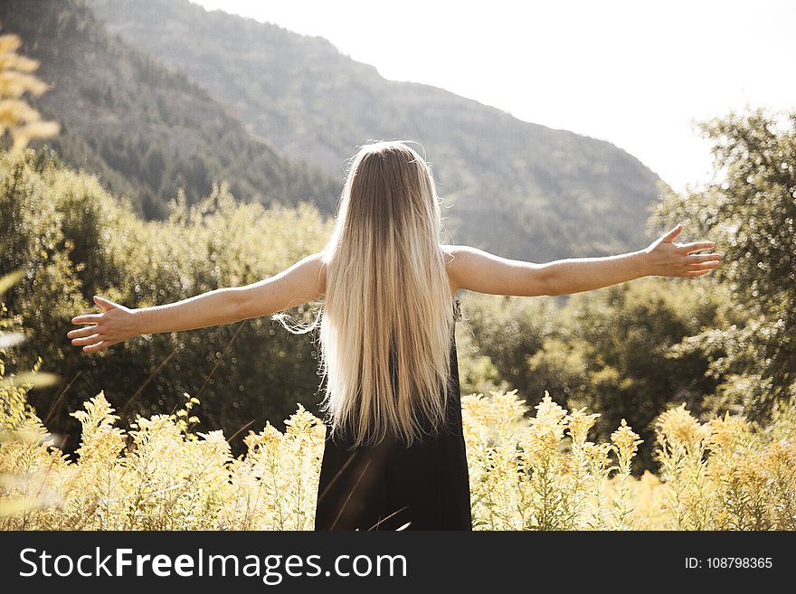 Standing Man in Black Dress Facing Mountain