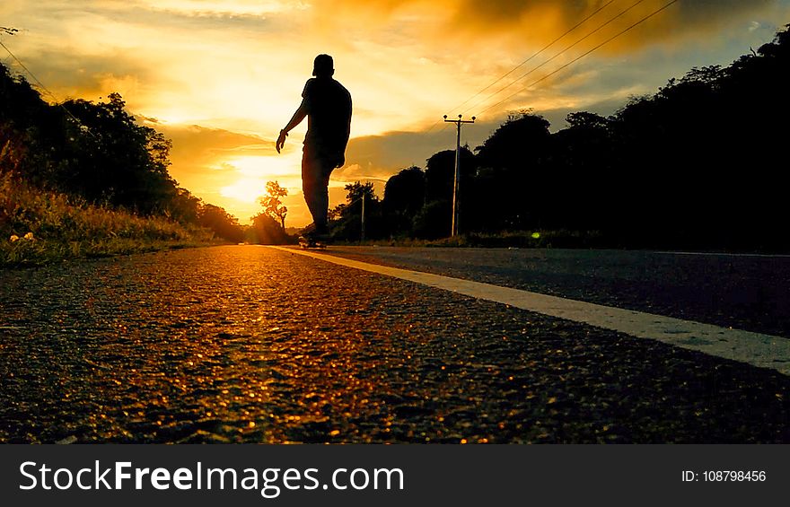 Silhouette Photo Of Man Riding Skateboard