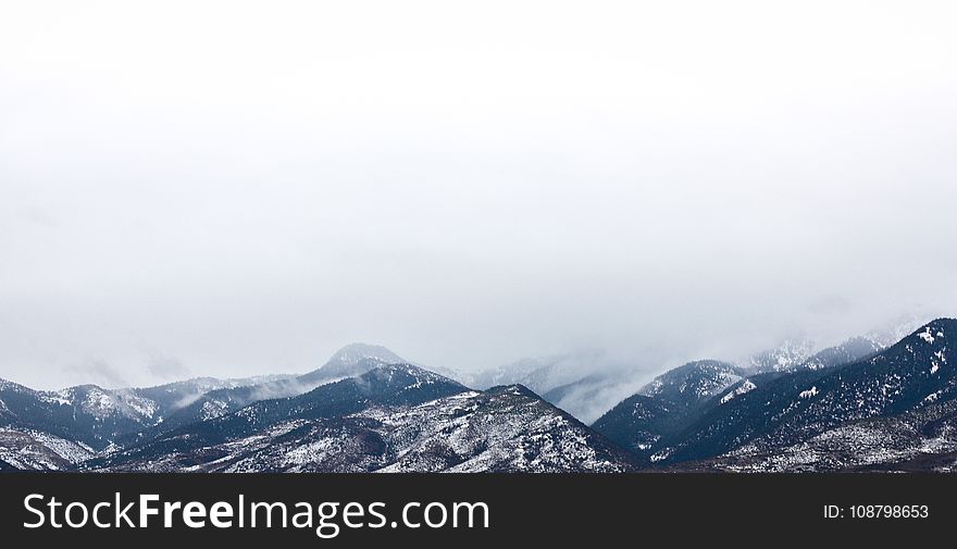 Snow Coated Mountain Under White Clouds