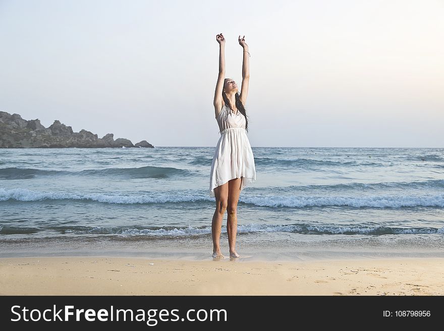 Photo Of Woman In White Sleeveless Dress Raising Hands