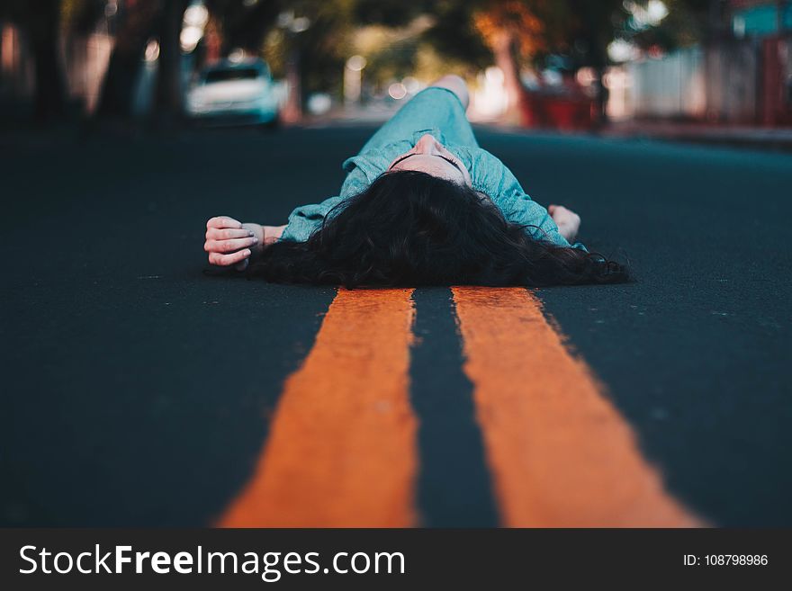 Woman in Blue Dress Lying Down on the Street