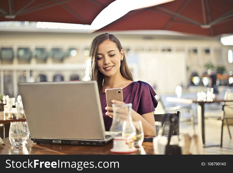 Woman Wearing Purple Shirt Holding Smartphone White Sitting On Chair