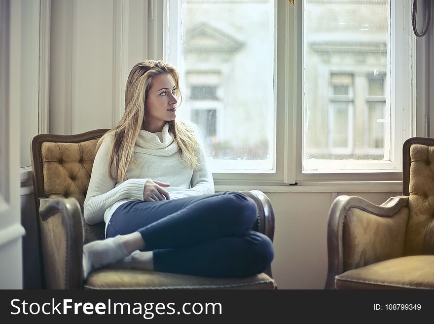 Photography Of Woman Sitting On Chair Near Window