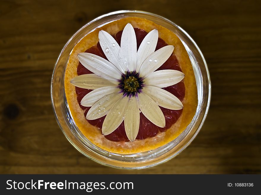 A fresh grapefruit decorated with a flower. A fresh grapefruit decorated with a flower