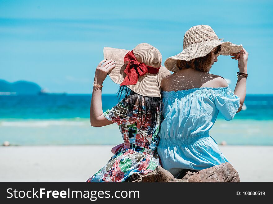 Young Asian woman wearing Hawaiian with hat and sunglasses is happy when they go to the beach