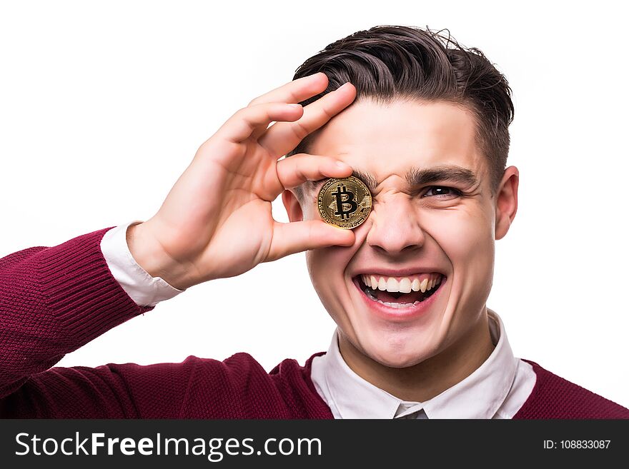 Close up of a joyful screaming businessman holding bitcoin at his face isolated over white background