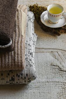 Cozy Warm Knitted Maxi Sweaters And Cup Of Tea On Wooden Background With Space For Text Royalty Free Stock Images