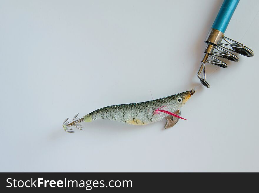 colorful plastic fishing bait on fishing pole on white background, space for text