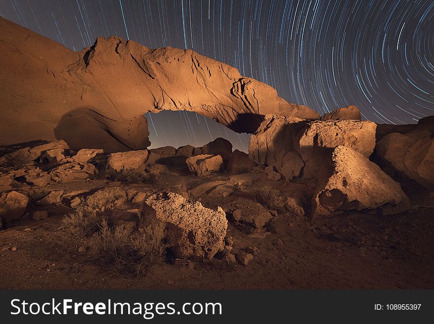 Star trails night landscape of a volcanic Rock arch in Tenerife, Canary island, Spain .