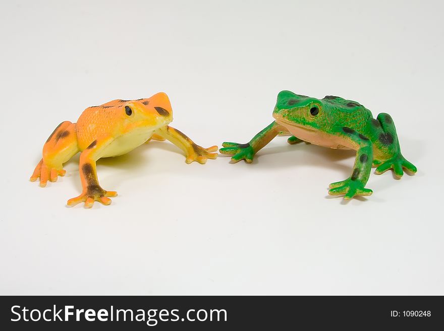 Two plastic frogs, one orange and the other green
