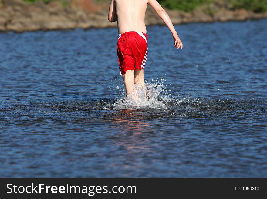 A young boy cooling of in lake on a hot summerday. A young boy cooling of in lake on a hot summerday