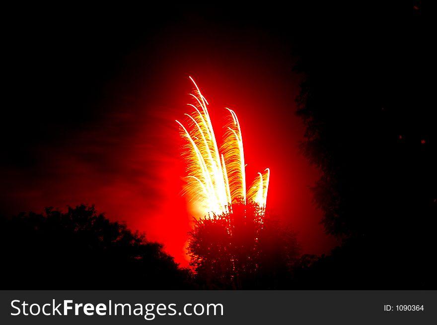 Red 'Fountain' Fireworks over Treetops. Red 'Fountain' Fireworks over Treetops