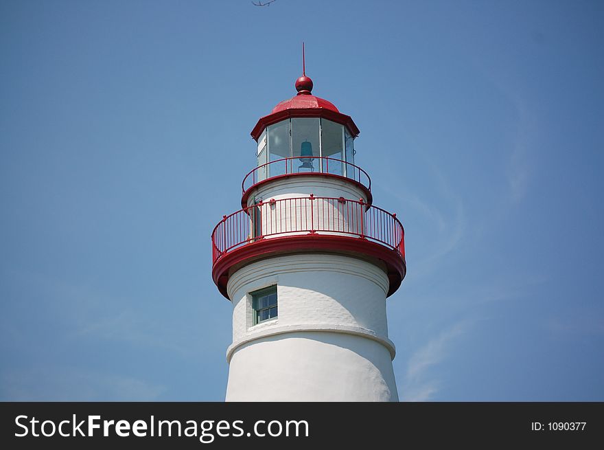 A close up of a lighthouse white and red.