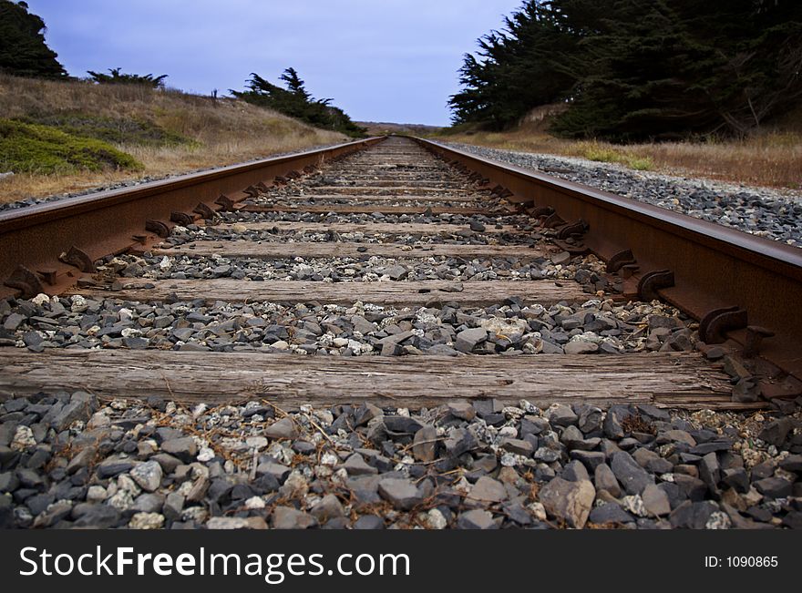 Railroad tracks heading out to blue sky horizon