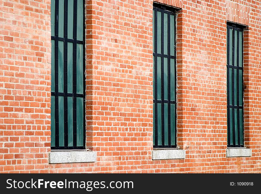 Three windows in old restored red brick building.