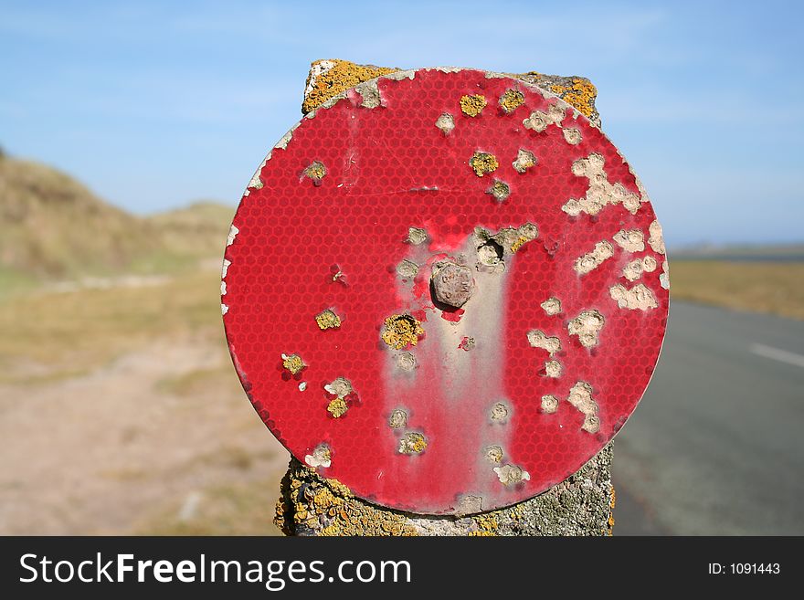 A red sign with lichen