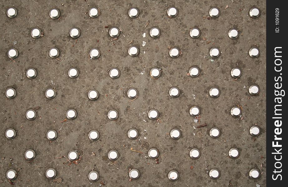Polkadots in steel on an English pavement. Polkadots in steel on an English pavement