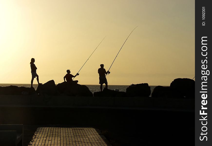 Three fisherman at sunset