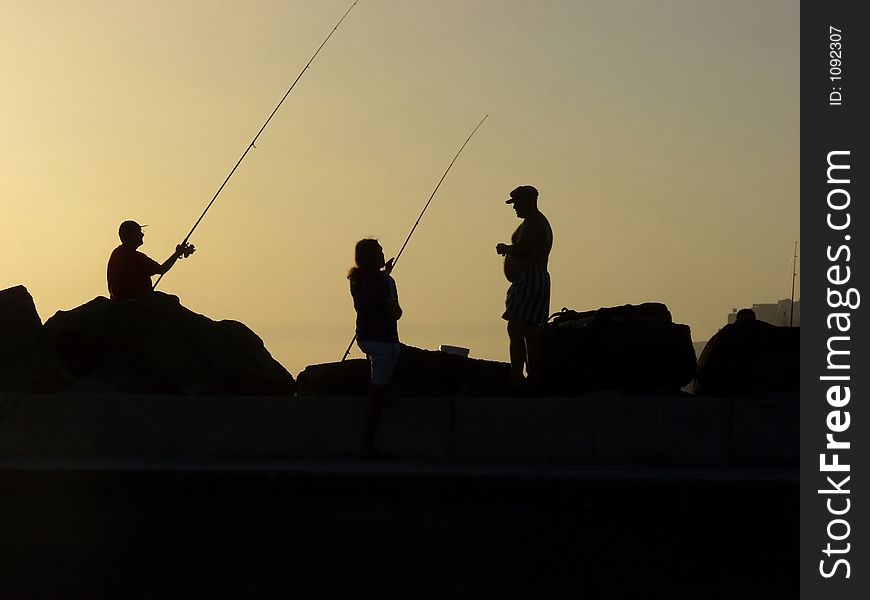 Three fisherman at sunset