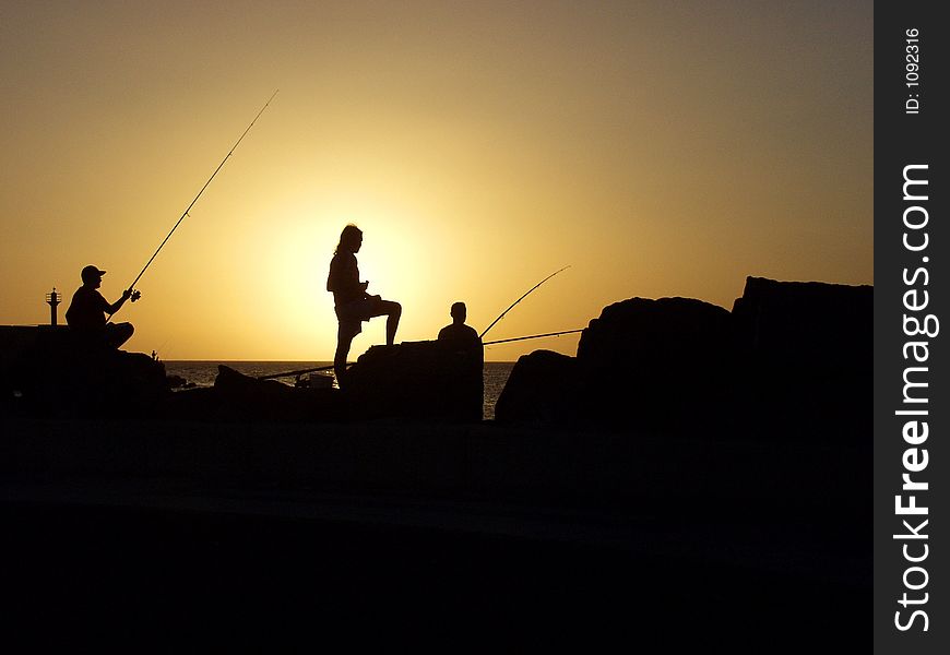 Three fisherman at sunset