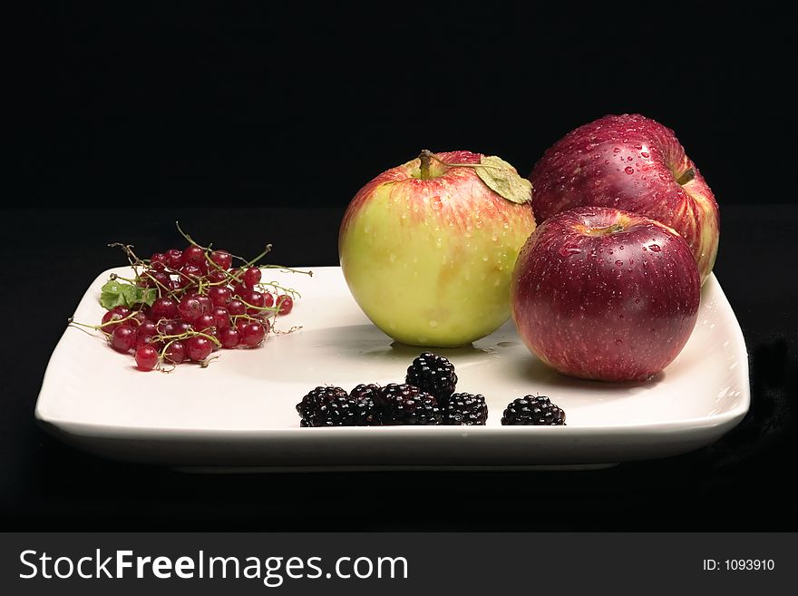 Plate with fruitson black background