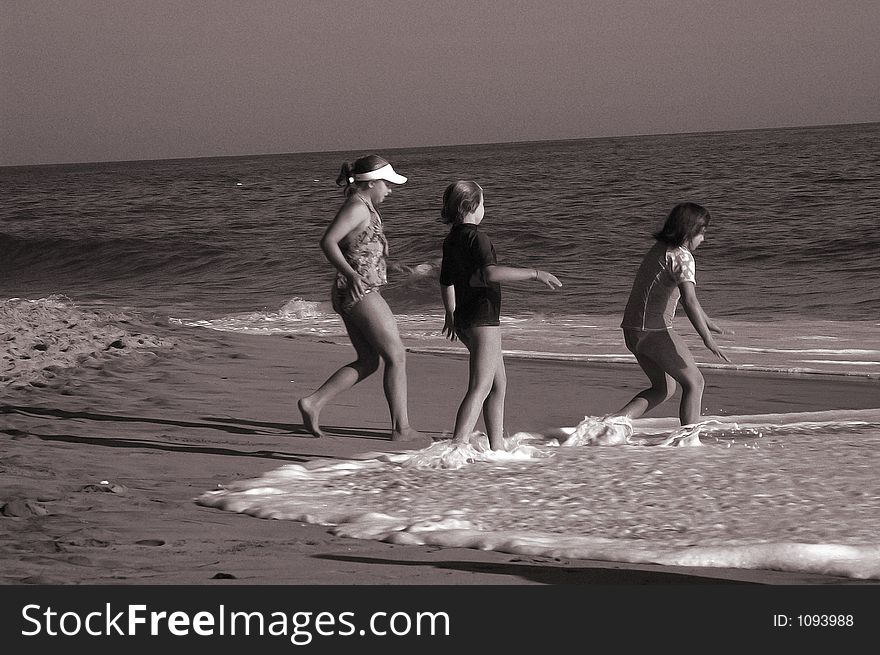 Three girls are running to the water on the beach. Three girls are running to the water on the beach