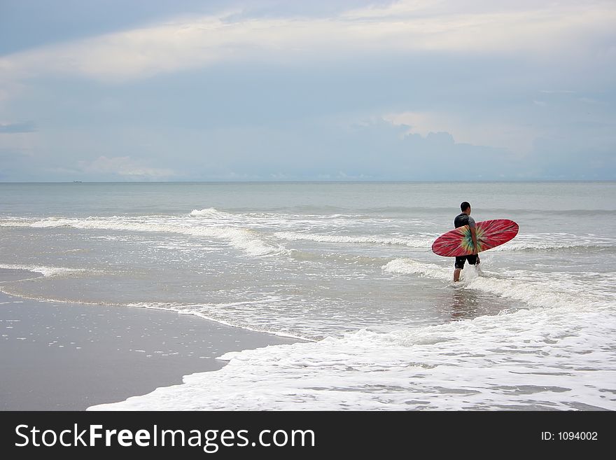 Man going into the ocean to surf. Man going into the ocean to surf