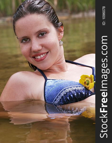 A beautiful young woman lying in the water of a lake for a recreation bath. A beautiful young woman lying in the water of a lake for a recreation bath.