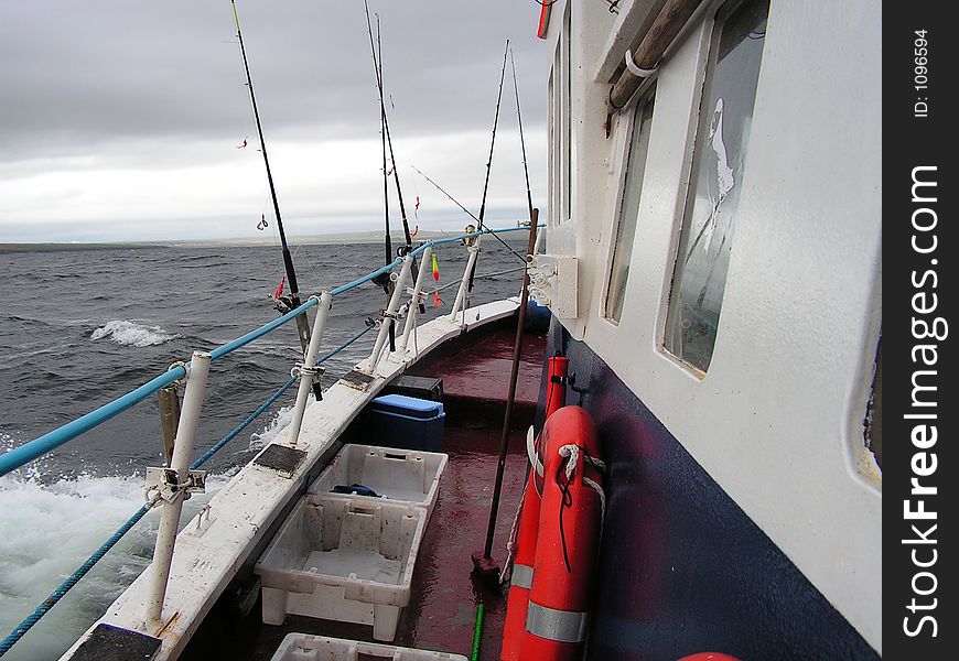 A view to the bow of a charter angling vessel rolling around in the inclement weather. Popular way of fishing from a boat. A view to the bow of a charter angling vessel rolling around in the inclement weather. Popular way of fishing from a boat