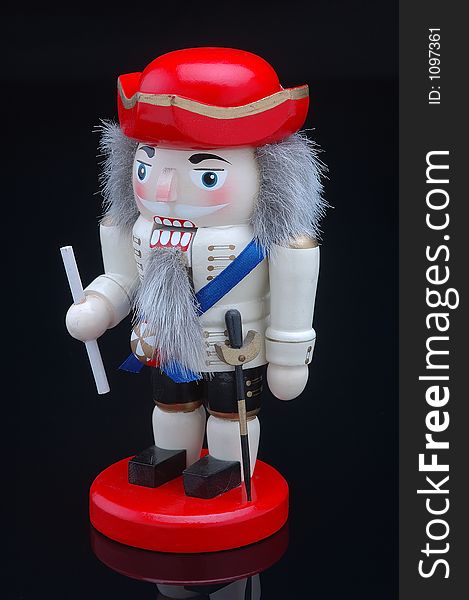 Military Nutcracker with red hat on a black background.