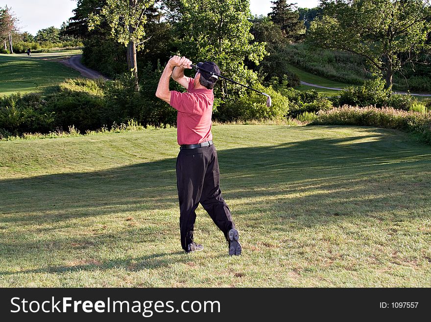 Golfer driving for the distant green. Golfer driving for the distant green.