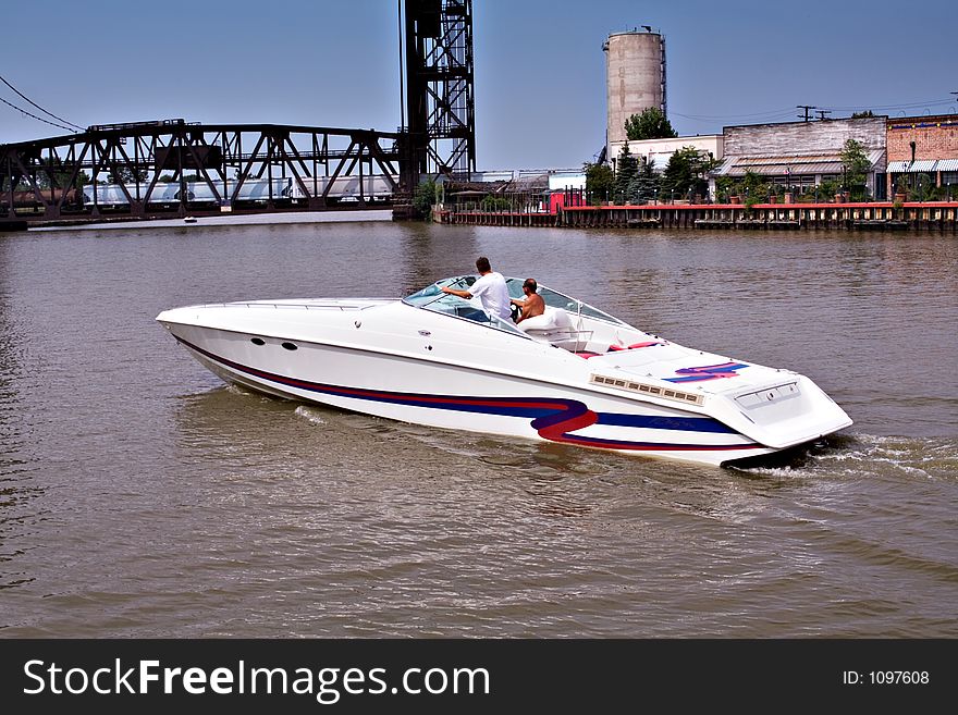 Two men crusing in a speedboat along the river that empties into Lake Erie. Railroad trestle bridge - train crossing. Bridge will raise after train has passes. Two men crusing in a speedboat along the river that empties into Lake Erie. Railroad trestle bridge - train crossing. Bridge will raise after train has passes.