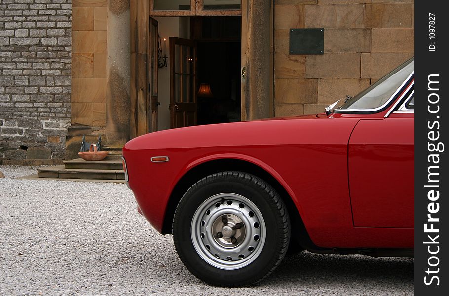 A classic italian sports car outside an english statley home. A classic italian sports car outside an english statley home
