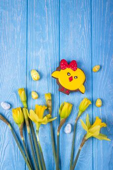 Happy Easter. Spring Flowers Yellow Daffodils, Easter Eggs And Gingerbread Chicken On A Blue Background. Top View, Free Space Royalty Free Stock Images Happy Easter. Spring Flowers Yellow Daffodils, Easter Eggs And Gingerbread Chicken On A Blue Background. Top View, Free Space Royalty Free Stock Images