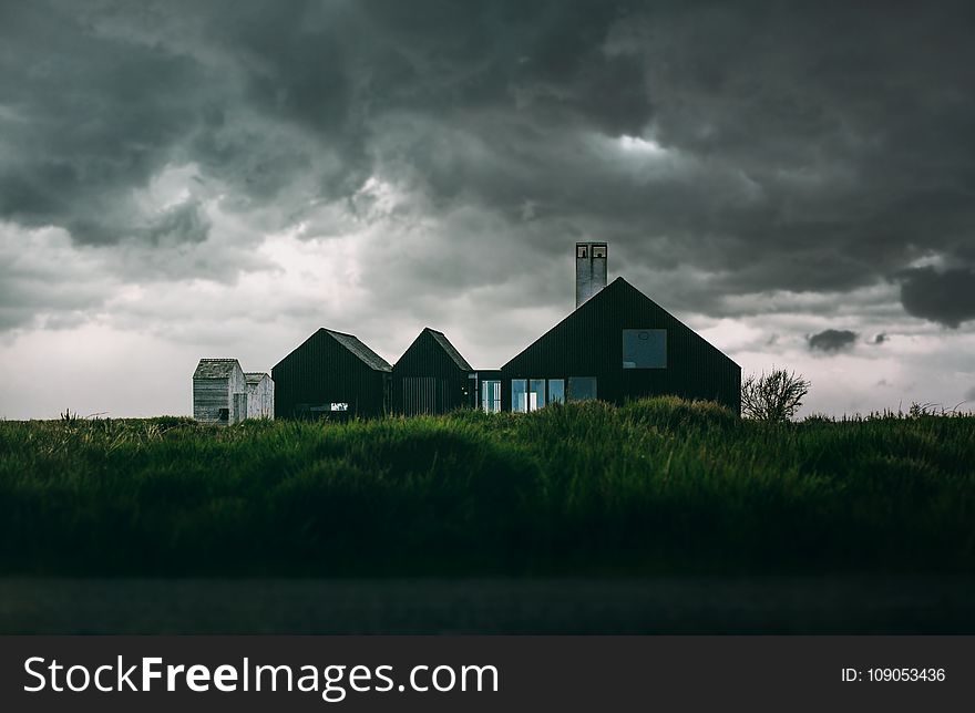 Black and White House Under Thick Clouds