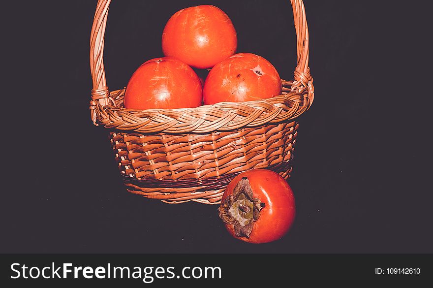 Delicious ripe persimmon, juicy orange fruits on black background, filtered. Delicious ripe persimmon, juicy orange fruits on black background, filtered.