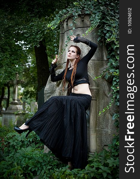 Tender looking gothic girl in black dancing at cemetery