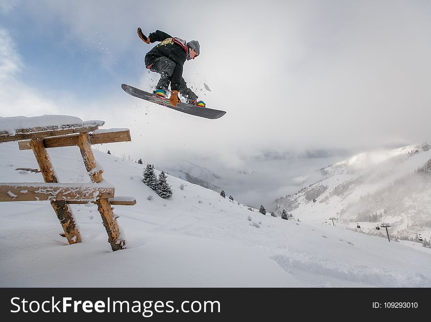 Man In Black Snowboard With Binding Performs A Jump