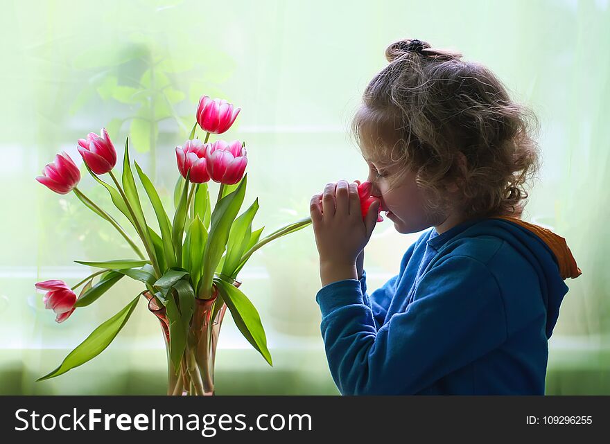 Little girl with bouquet of tulip flowers.