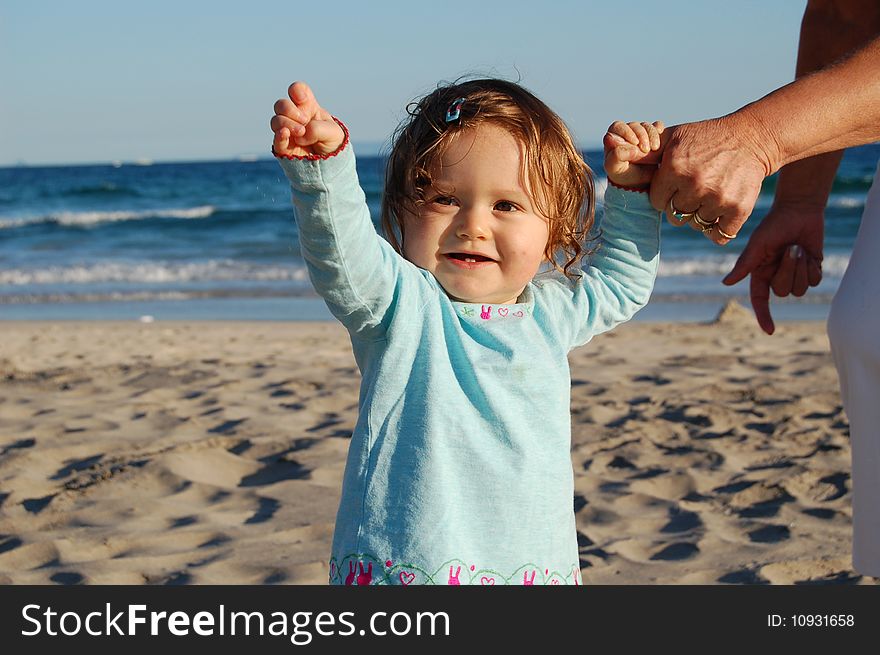 The first steps of a one year old, holding onto her grandmother's hand