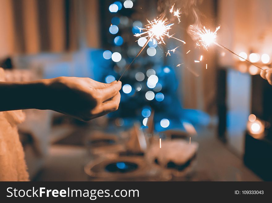 Close Up Photograph Of Two Person Holding Sparklers