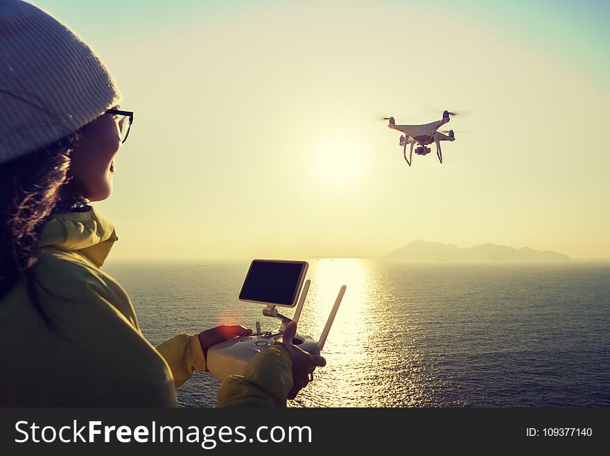 Remote Control A Flying Drone Which Taking Photo Over Sunrise Sea