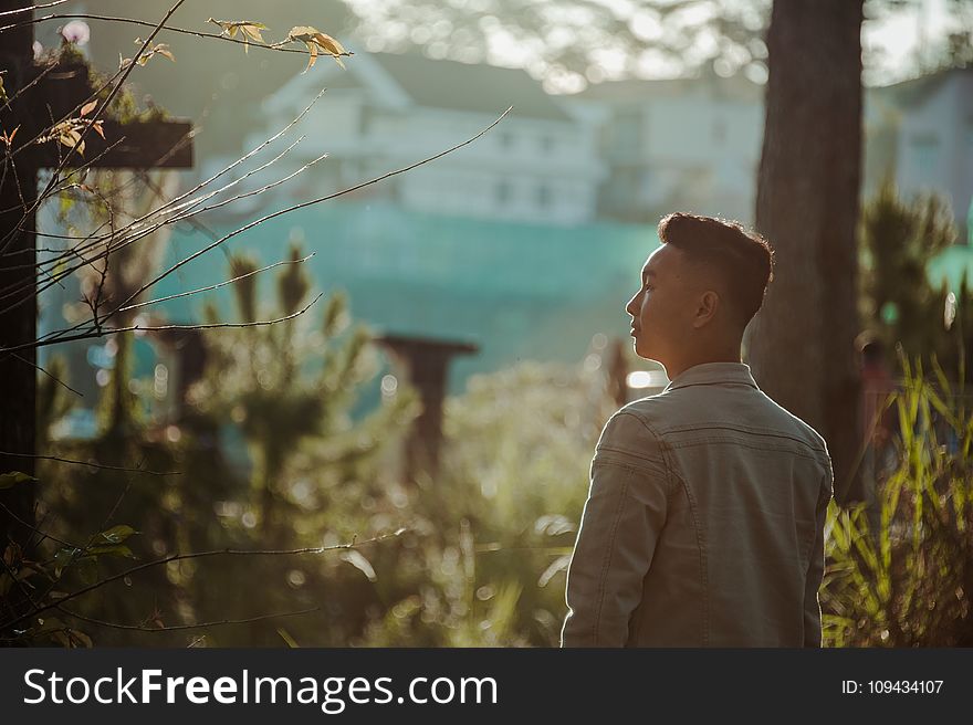 Man Wearing Gray Dress Shirt Standing Near Green Leaf Plant